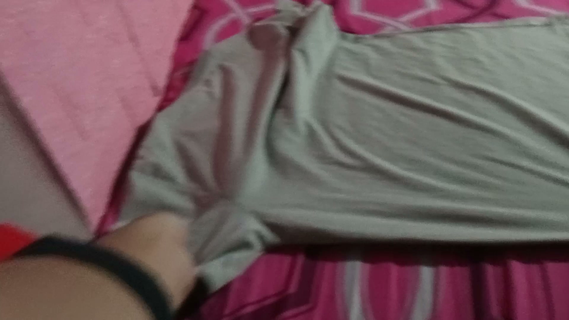 First-person Eidon Tracker POV frame showing a hand gripping grey fabric on pink patterned bedding; still extracted at 10 seconds from recording 1000, by Solidic Labs Inc (Eidon AI), CC BY 4.0